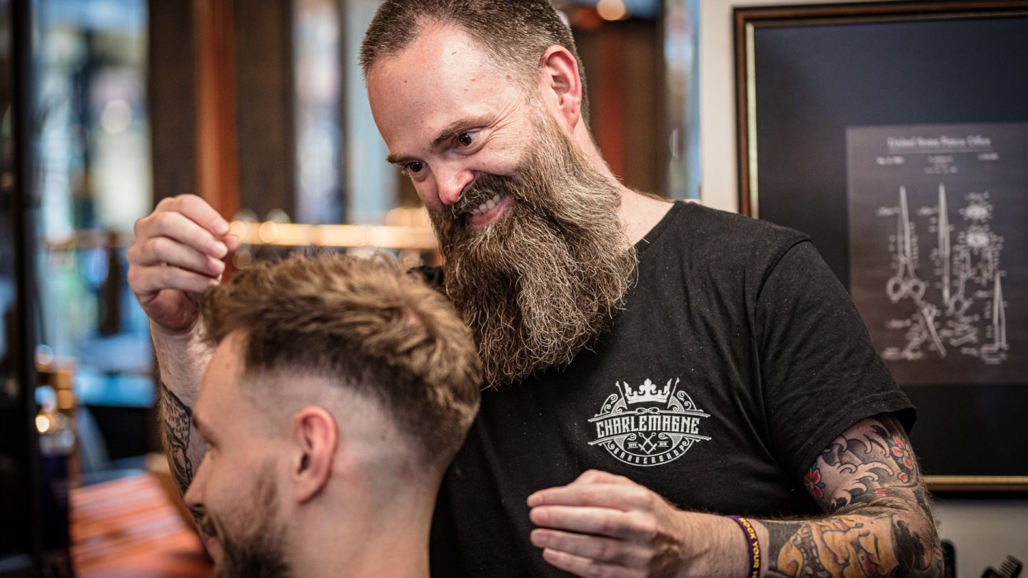 Mike Crott stylt die Haare eines Kunden